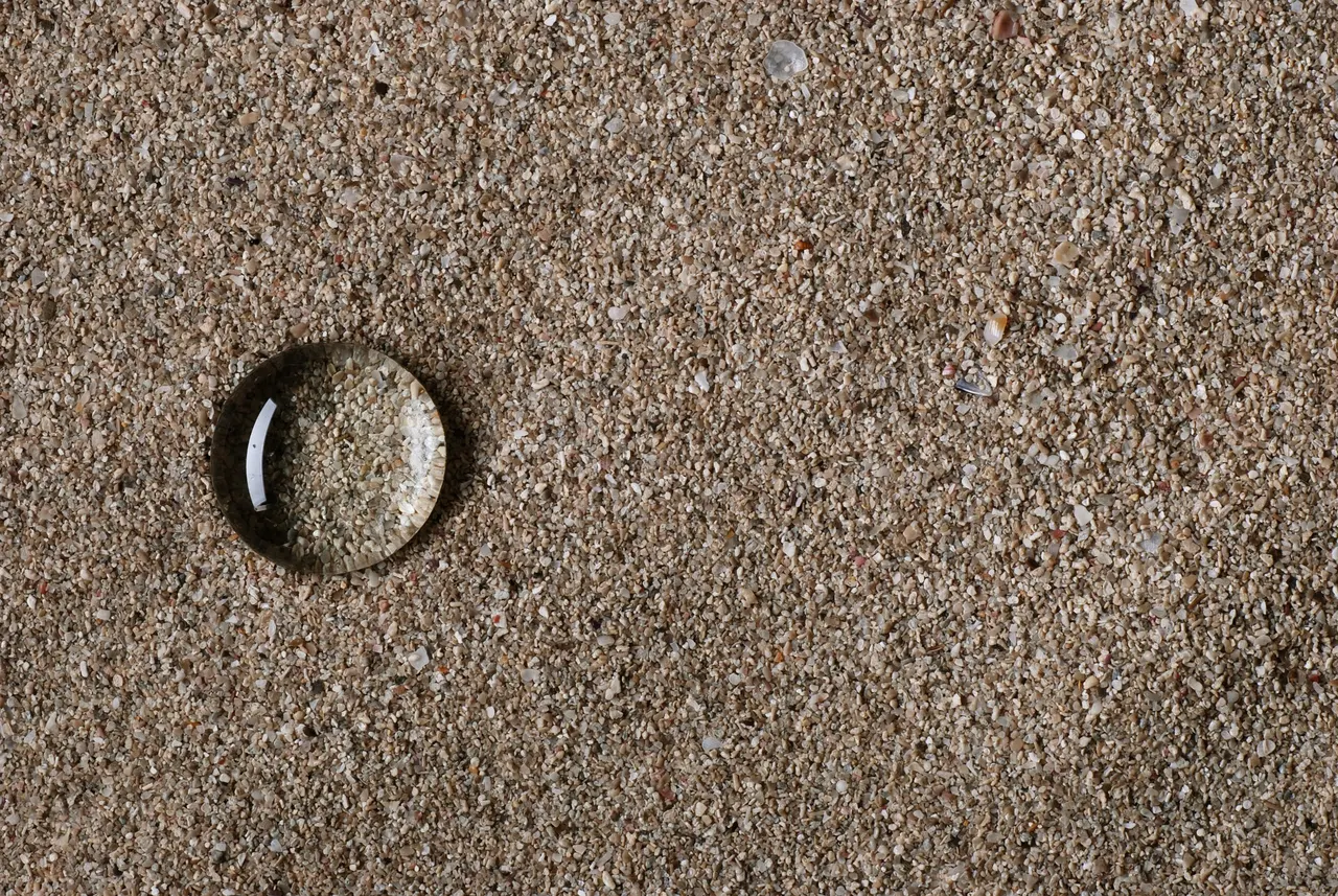 Water droplet beading on water repellent sand instead of soaking in